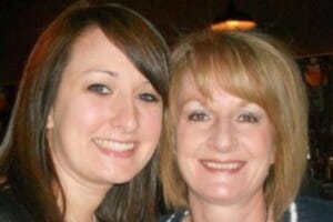 A smiling blonde woman with her smiling brunette daughter.
