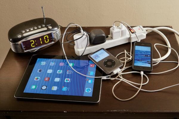 Tangled chargers for electronics on a desk.