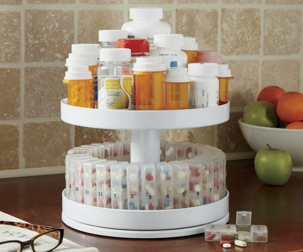 A two-tier rotating medicine center with top tier for pill bottles and bottom for compartments for daily doses.