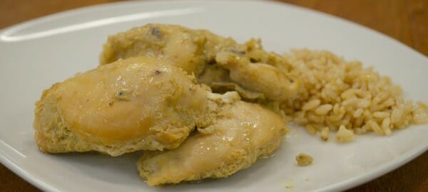 A white plate with a serving of rice and Best Chicken Ever topped with a sauce.