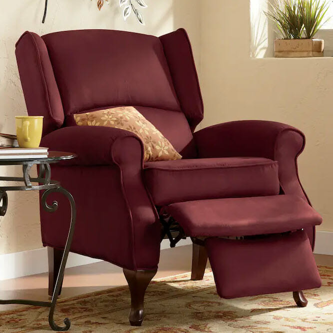 burgundy microfiber wingback chair with orange throw pillow