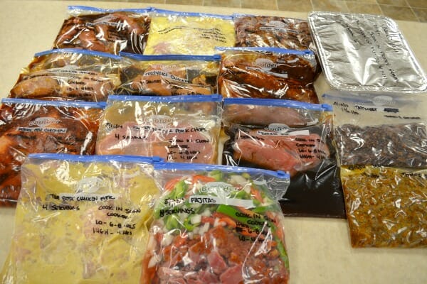 14 labeled freezer bags filled with different homemade meals, ready for a busy day.