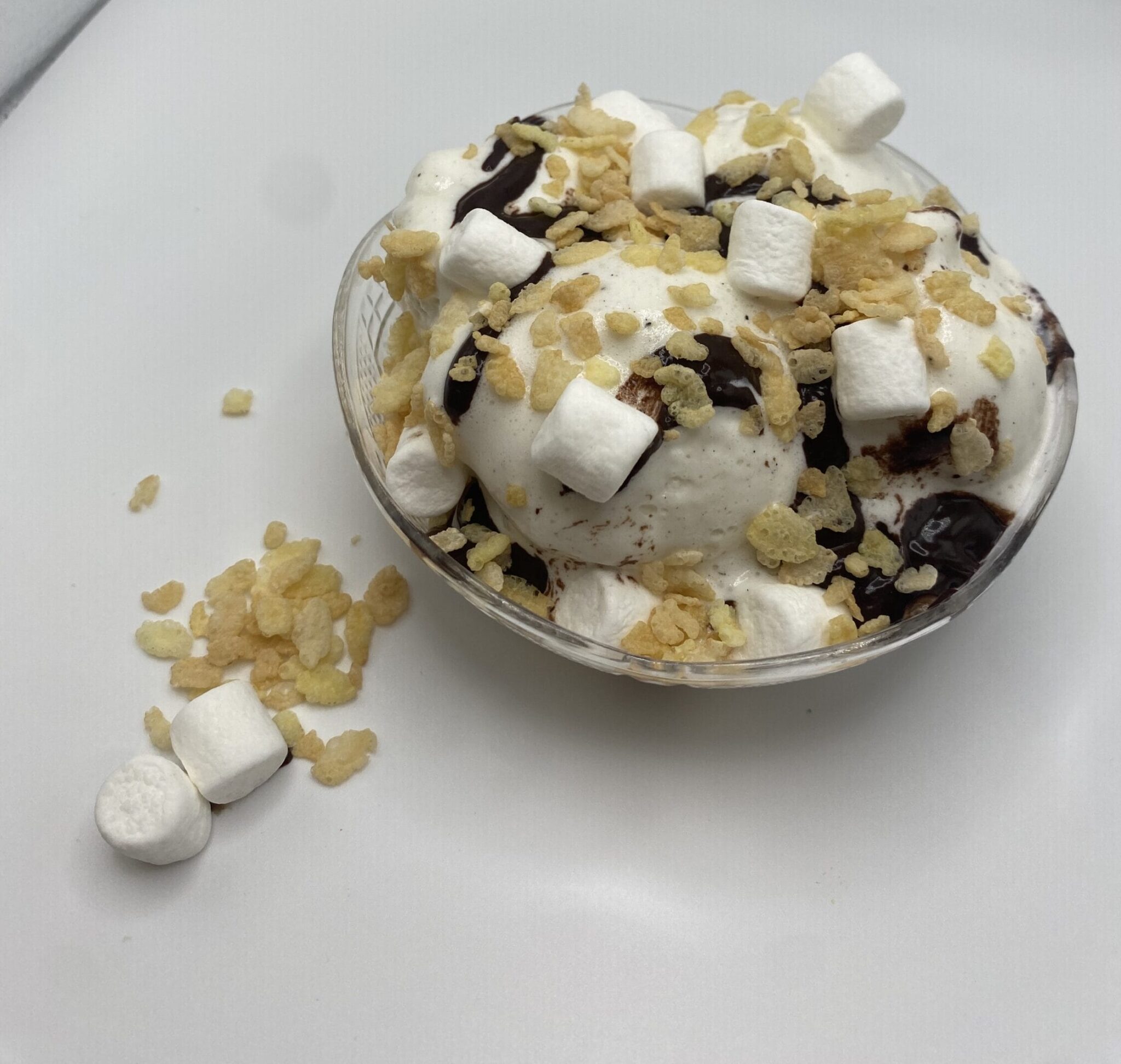 Ice cream bowl with vanilla ice cream, marshmallows, crispy rice cereal, and chocolate syrup