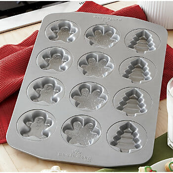 A silver cookie pan with embossed gingerbread men, snowflakes, and pine trees designs.