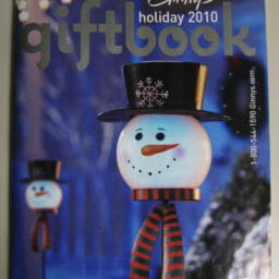 Ginny's Holiday 2010 catalog cover of solar snowmen heads lining a walk at night.