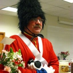 A man with glasses in an office, dressed as a tin soldier.