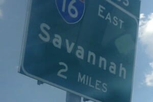 A green highway sign for Interstate 16 East, Savannah GA, 2 miles.