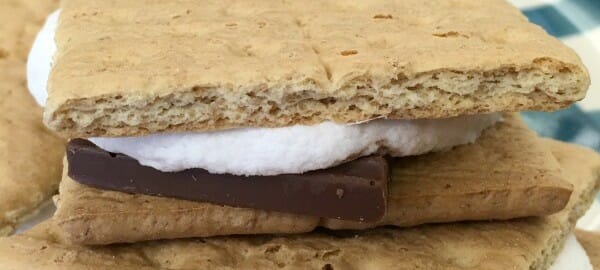 Stacked S'mores made with Graham crackers, chocolate bar pieces, and marshmallows.