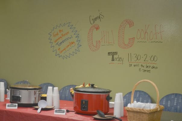 Ginny's Chili Cookoff Today 11:30-2:00 or until the last drop is served - A table set with slow cookers, cups and spoons. 