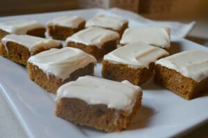 A white platter of Pumpkin Bars with cream cheese frosting.