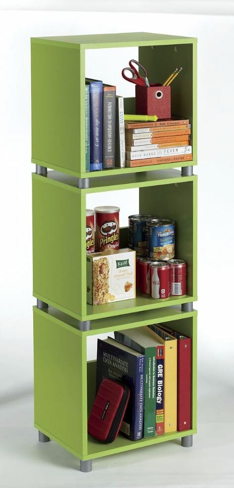 Three green wood cubes with legs stacked on top of each other, holding books, soup cans, and snacks.