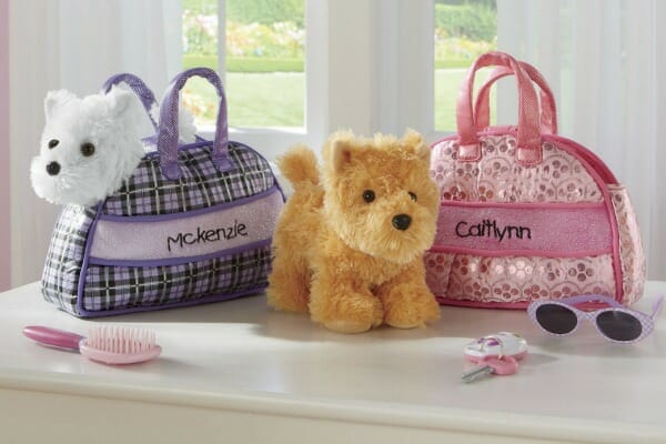 Two children's personalized plush dog and purse sets, a white dog with a purple plaid, and a tan dog with a pink print.