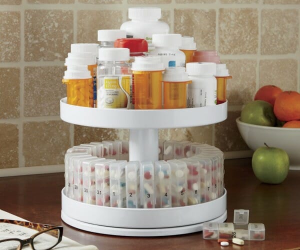 A two-tier rotating medicine center with top tier for pill bottles and bottom for compartments for daily doses. 