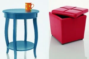 A blue round side table with an orange mug with lime dots placed on top, and a red storage ottoman.
