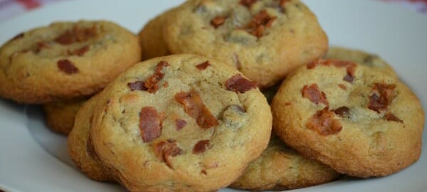 A red and white check cloth with a white plate filled with Chocolate Chip Bacon Cookies.