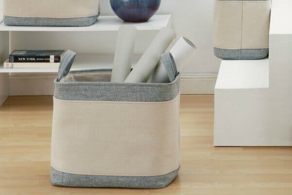 Fabric storage bins in Ivory and gray heather, next to white shelves and steps. 