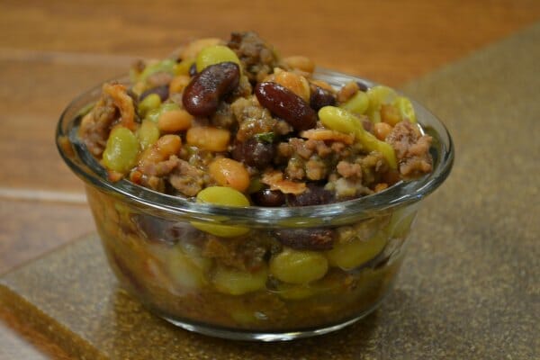 A clear glass bowl filled with a serving of One Pot Cowboy Beans.