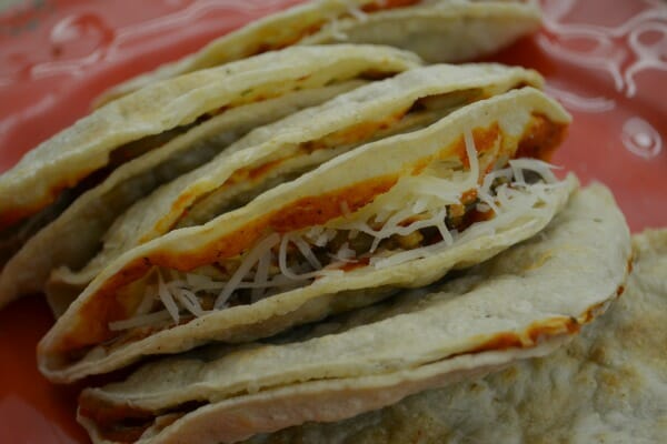 A red plate filled with six Pizza Tacos.