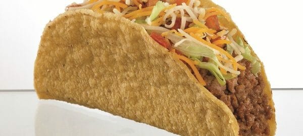 A taco in a crisp shell, topped with lettuce, tomato, and shredded cheese.