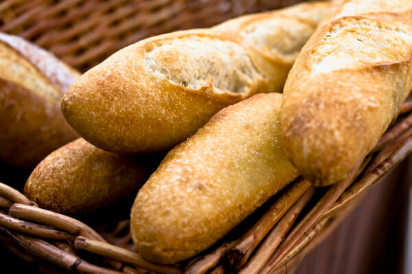A woven basket filled with five loaves of French Bread.