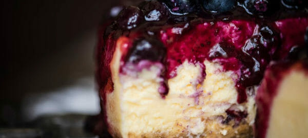 Close-up of a slice of Cheesecake with a juicy blueberry topping.