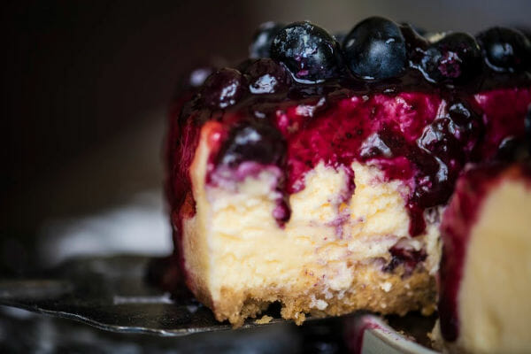 Close-up of a slice of Cheesecake with a juicy blueberry topping.