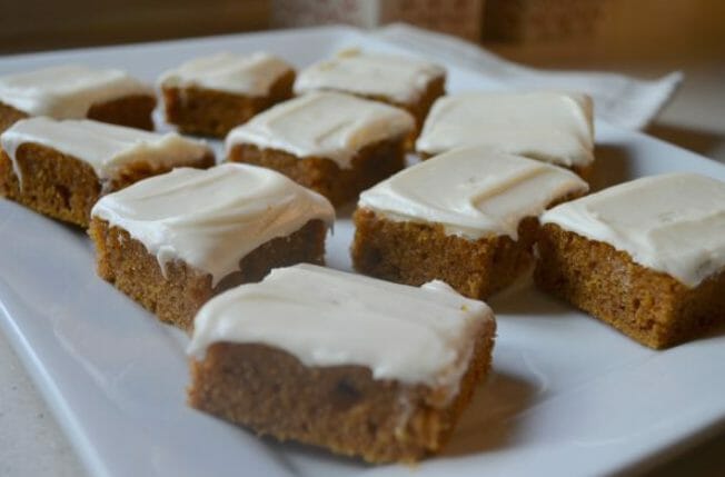 A white platter of Pumpkin Bars with cream cheese frosting.