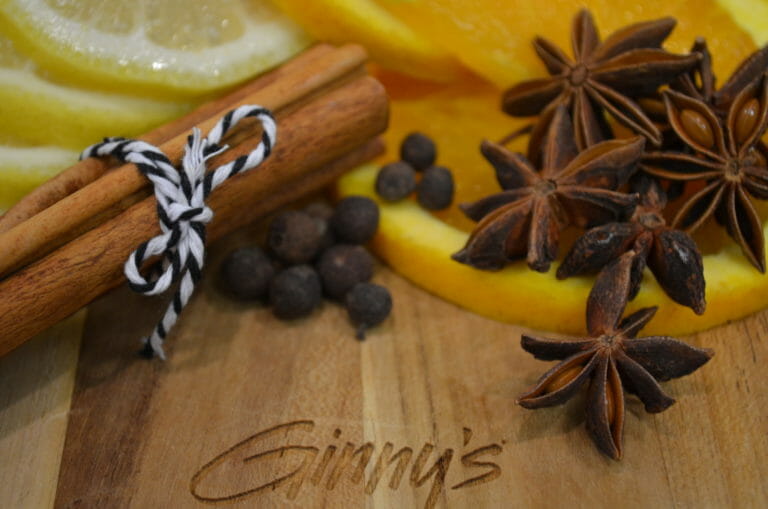 cinnamon sticks, coffee beans, lemon slices and orange slices on a cutting board