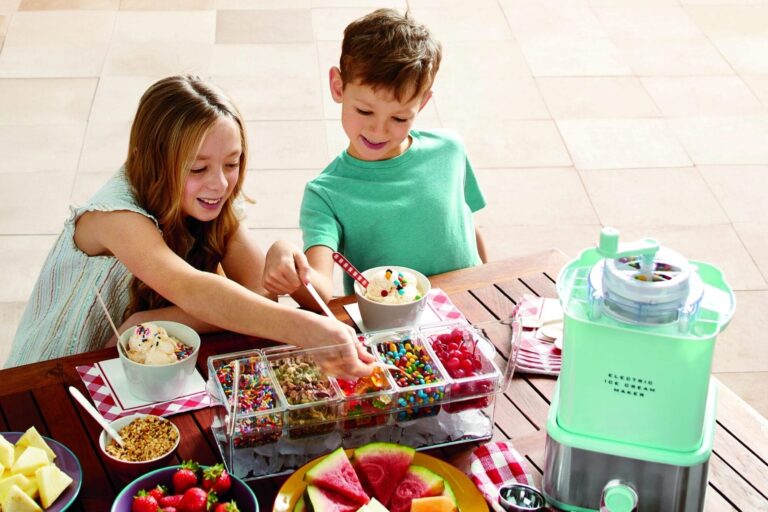 Two children adding toppings to their ice cream sundaes next to an ice cream maker