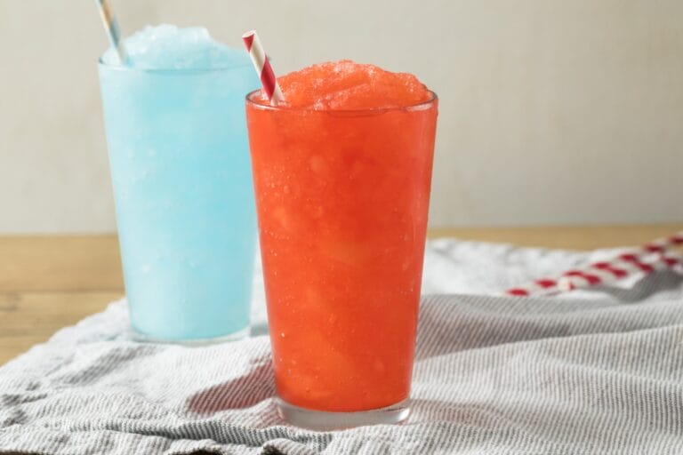 Two glasses of slushy drinks with a straw